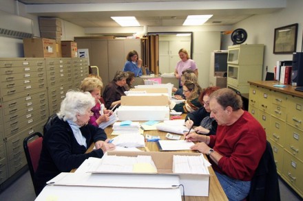 Volunteers matching records for ballots received against those distributed